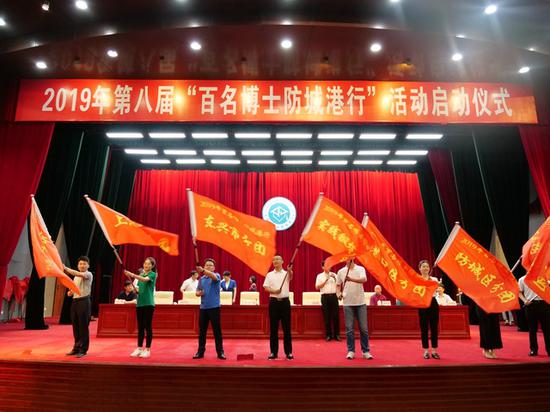 参加授旗仪式的各博士团分团代表在启动仪式上挥舞旗帜。 中国青年报·中国青年网记者 谢洋摄