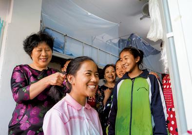 10月1日，在南昌市第十七中学宿舍，刘和平（左一）为一名西藏班学生梳头。