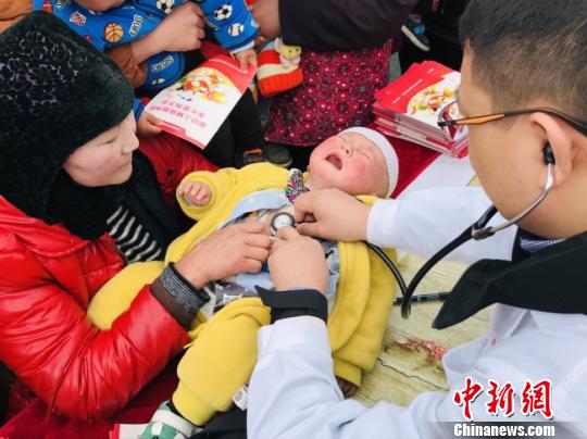 图为甘肃省妇幼保健院的专家为当地儿童义诊。　闫姣 摄